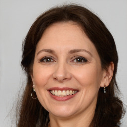 Joyful white adult female with long  brown hair and brown eyes