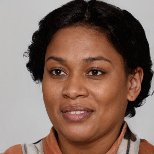 Joyful black adult female with short  brown hair and brown eyes