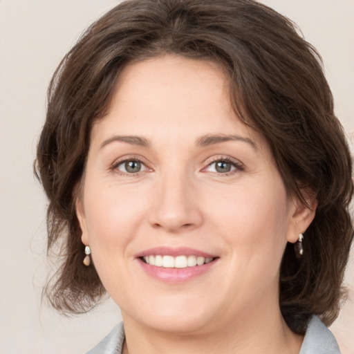 Joyful white young-adult female with medium  brown hair and green eyes