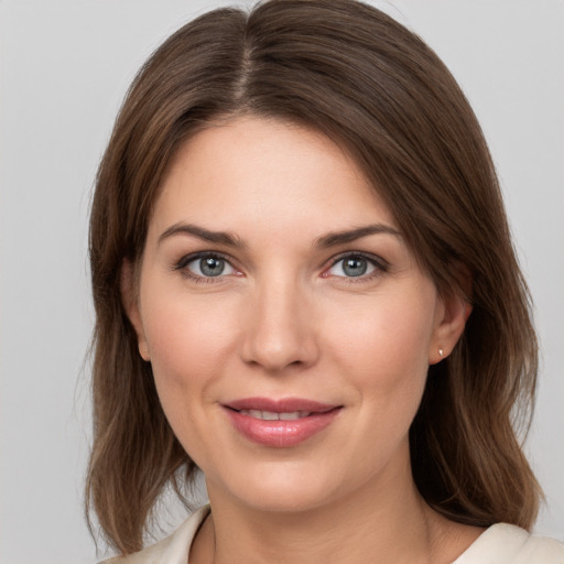 Joyful white young-adult female with medium  brown hair and grey eyes