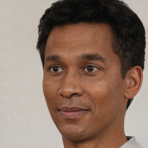 Joyful black adult male with short  black hair and brown eyes