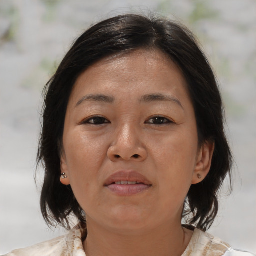 Joyful asian adult female with medium  brown hair and brown eyes