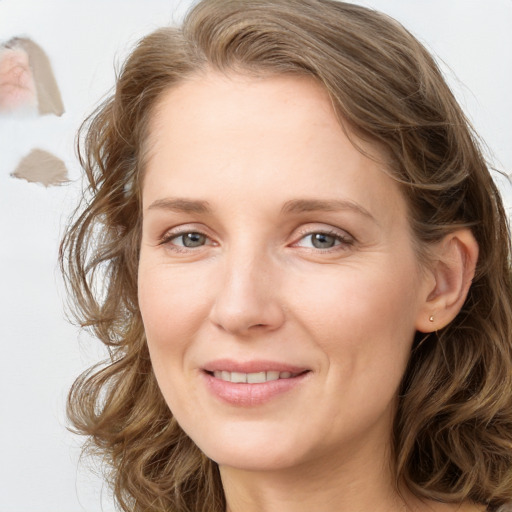 Joyful white young-adult female with long  brown hair and blue eyes