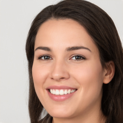 Joyful white young-adult female with long  brown hair and brown eyes