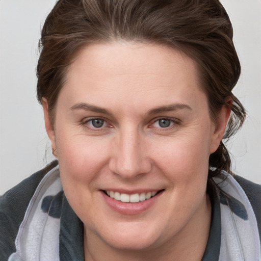 Joyful white young-adult female with medium  brown hair and grey eyes