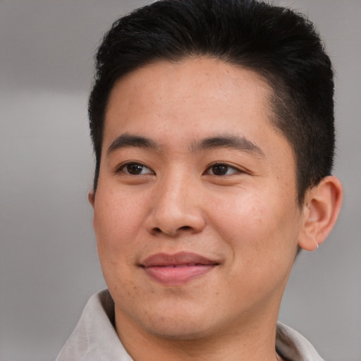 Joyful asian young-adult male with short  brown hair and brown eyes