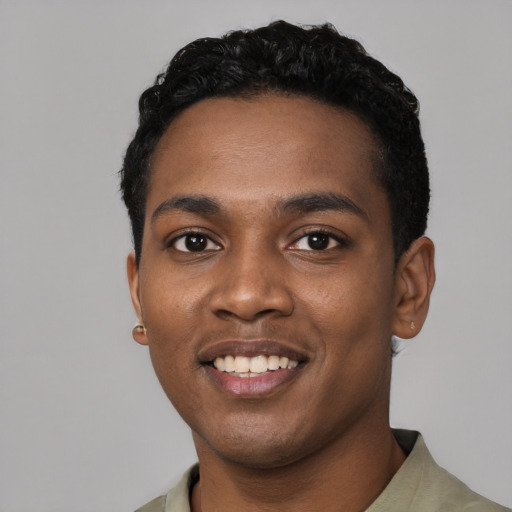 Joyful black young-adult male with short  black hair and brown eyes