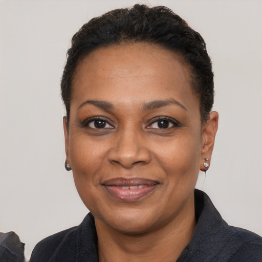 Joyful black adult female with short  black hair and brown eyes