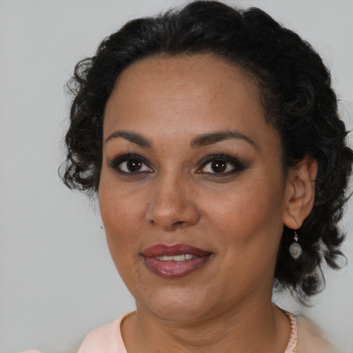 Joyful black adult female with medium  brown hair and brown eyes