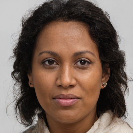 Joyful black adult female with long  brown hair and brown eyes