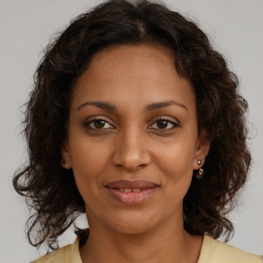 Joyful black young-adult female with medium  brown hair and brown eyes