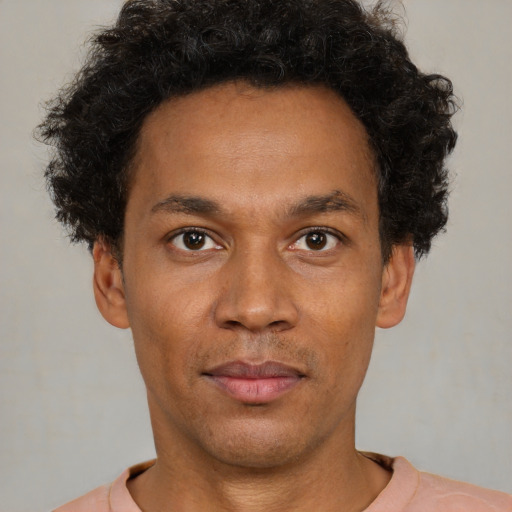 Joyful latino young-adult male with short  brown hair and brown eyes