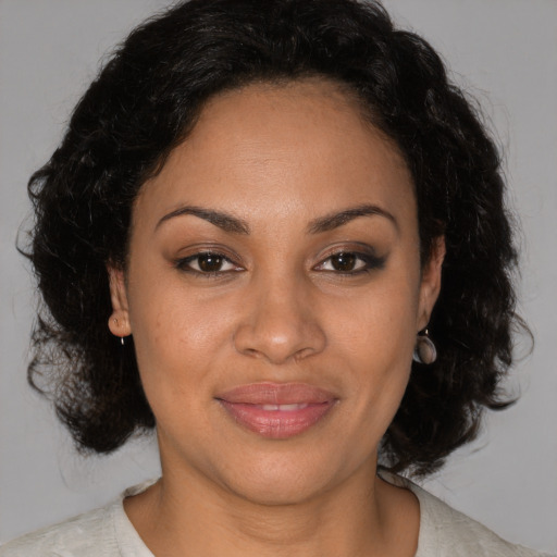 Joyful black adult female with medium  brown hair and brown eyes
