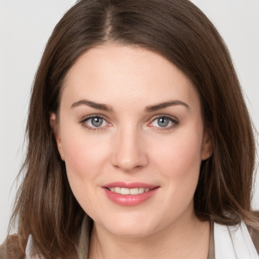 Joyful white young-adult female with long  brown hair and grey eyes