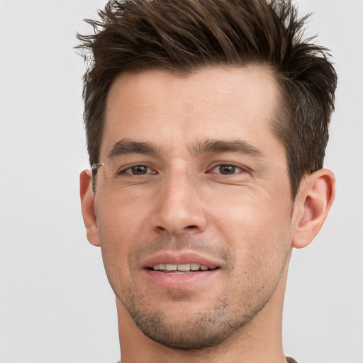 Joyful white young-adult male with short  brown hair and grey eyes