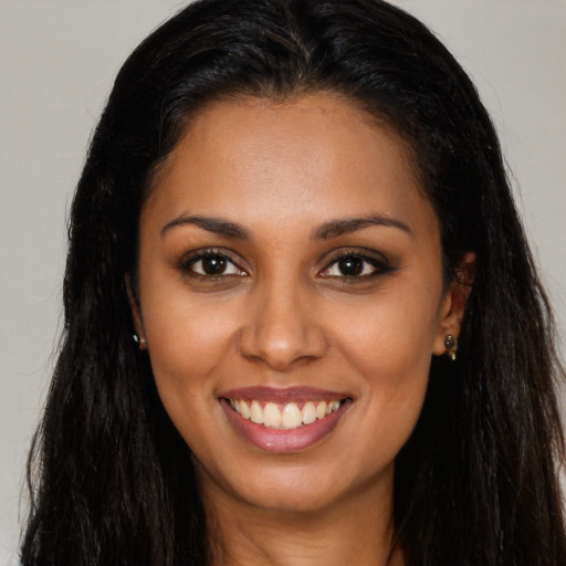 Joyful latino young-adult female with long  brown hair and brown eyes