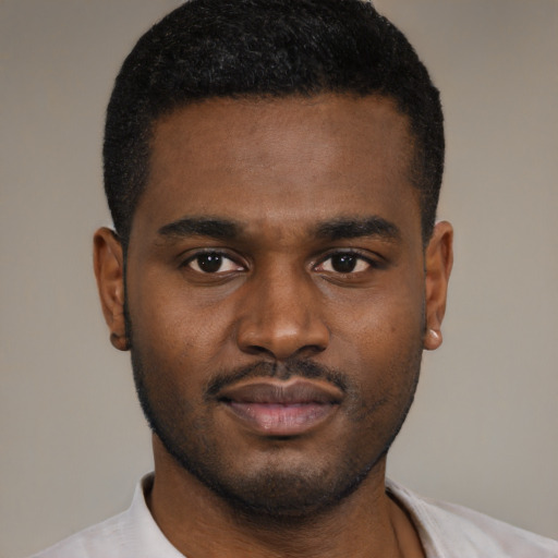 Joyful black young-adult male with short  black hair and brown eyes
