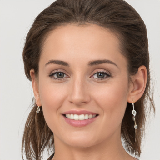 Joyful white young-adult female with medium  brown hair and grey eyes