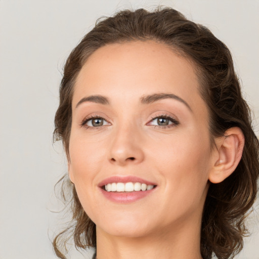 Joyful white young-adult female with medium  brown hair and green eyes