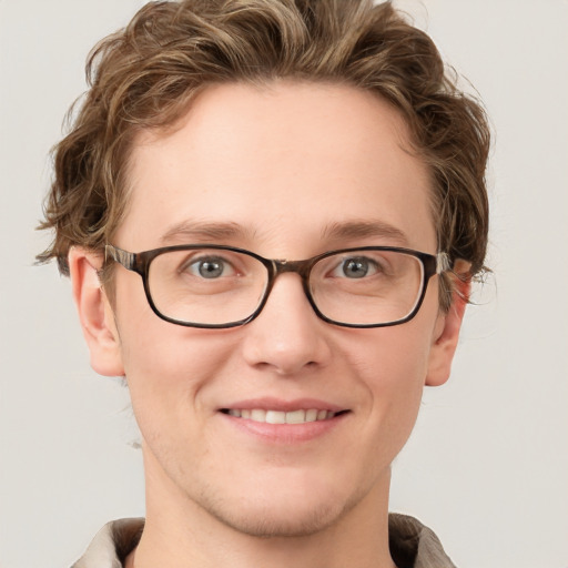 Joyful white young-adult male with short  brown hair and blue eyes