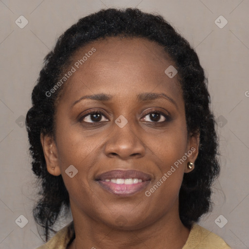 Joyful black adult female with long  brown hair and brown eyes