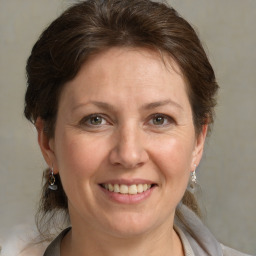 Joyful white adult female with medium  brown hair and grey eyes