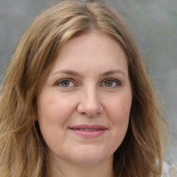 Joyful white adult female with medium  brown hair and green eyes