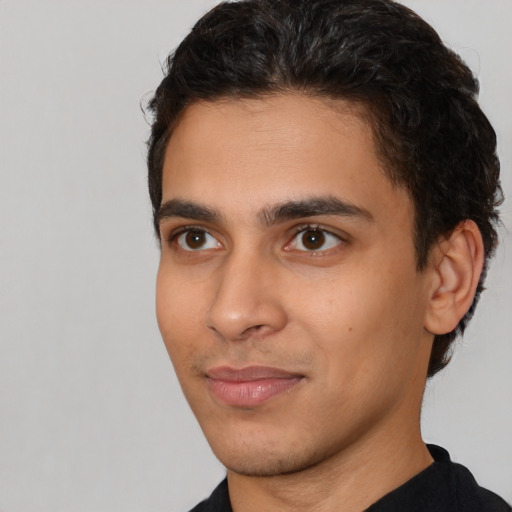 Joyful latino young-adult male with short  brown hair and brown eyes