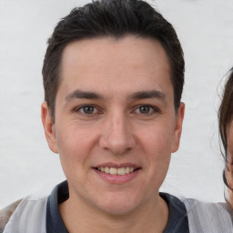 Joyful white young-adult male with short  brown hair and brown eyes