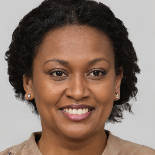Joyful black adult female with short  brown hair and brown eyes