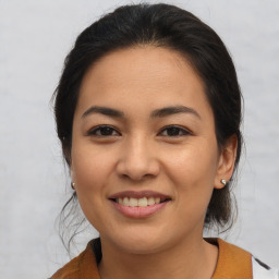 Joyful latino young-adult female with medium  brown hair and brown eyes