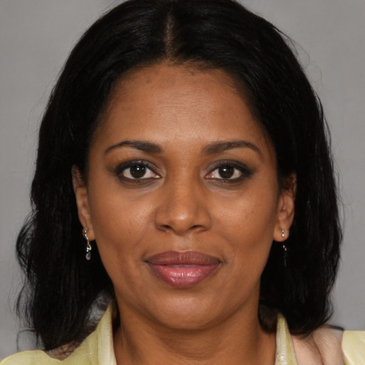 Joyful latino adult female with medium  brown hair and brown eyes
