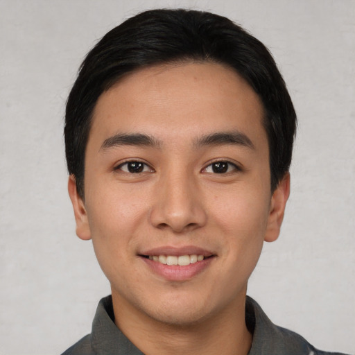 Joyful asian young-adult male with short  black hair and brown eyes