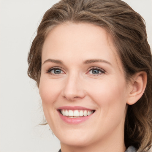 Joyful white young-adult female with medium  brown hair and green eyes