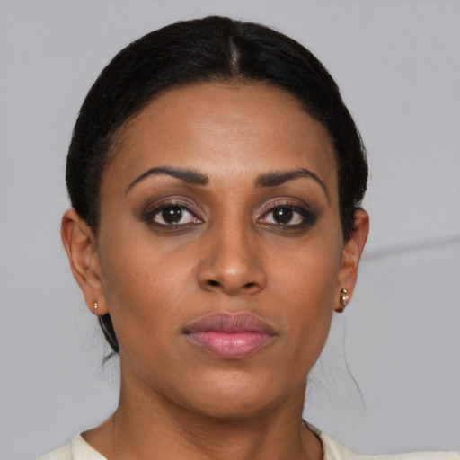 Joyful black young-adult female with short  brown hair and brown eyes