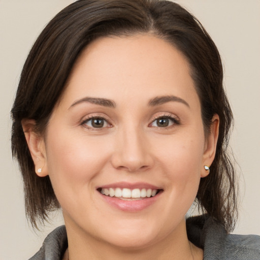 Joyful white young-adult female with medium  brown hair and brown eyes