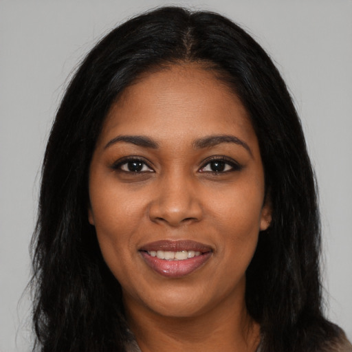 Joyful black young-adult female with long  black hair and brown eyes