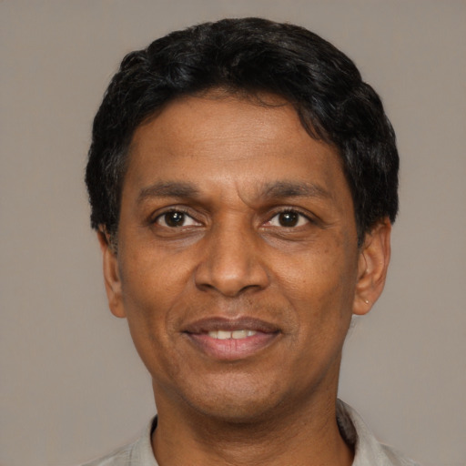 Joyful latino adult male with short  black hair and brown eyes