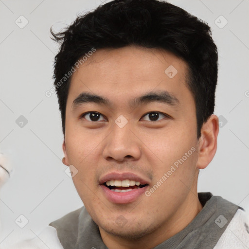 Joyful asian young-adult male with short  black hair and brown eyes