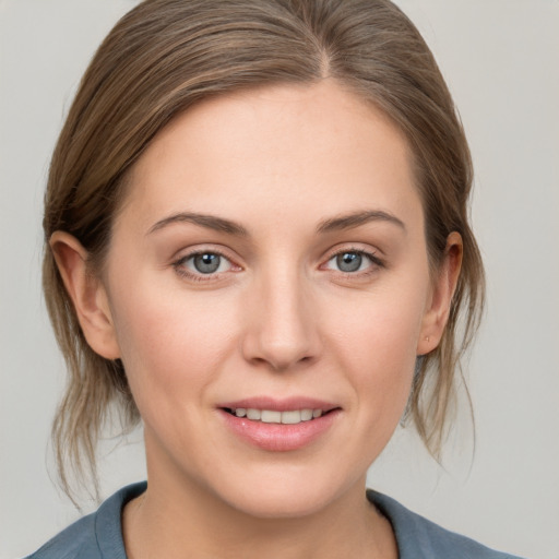 Joyful white young-adult female with medium  brown hair and grey eyes