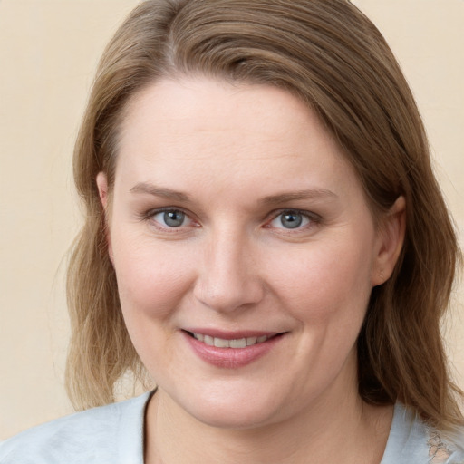 Joyful white young-adult female with medium  brown hair and blue eyes