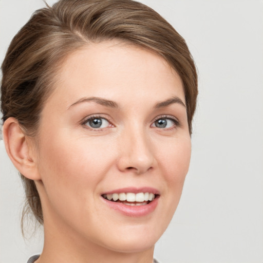 Joyful white young-adult female with short  brown hair and grey eyes