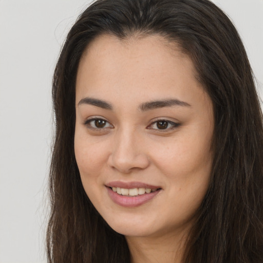 Joyful asian young-adult female with long  brown hair and brown eyes