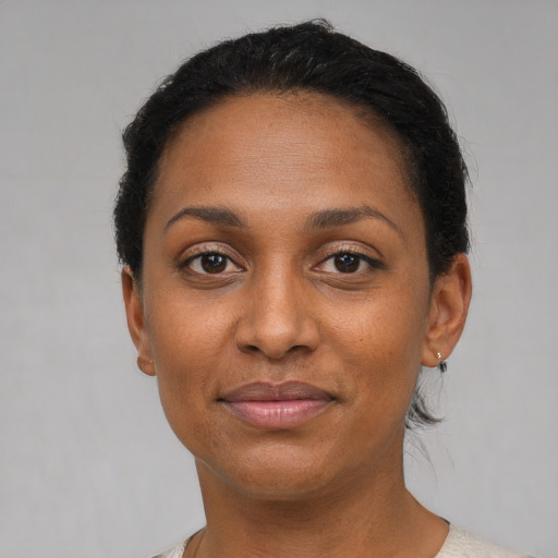 Joyful black adult female with short  black hair and brown eyes