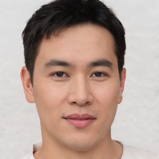 Joyful asian young-adult male with short  brown hair and brown eyes