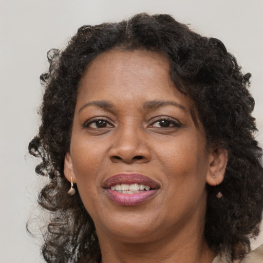 Joyful black adult female with medium  brown hair and brown eyes