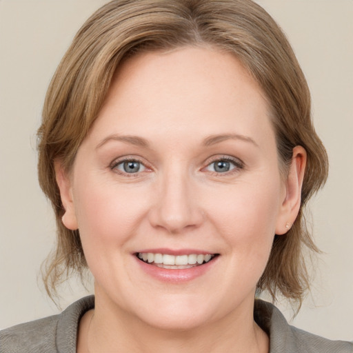 Joyful white young-adult female with medium  brown hair and blue eyes