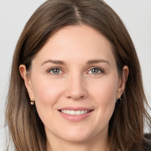 Joyful white young-adult female with long  brown hair and grey eyes