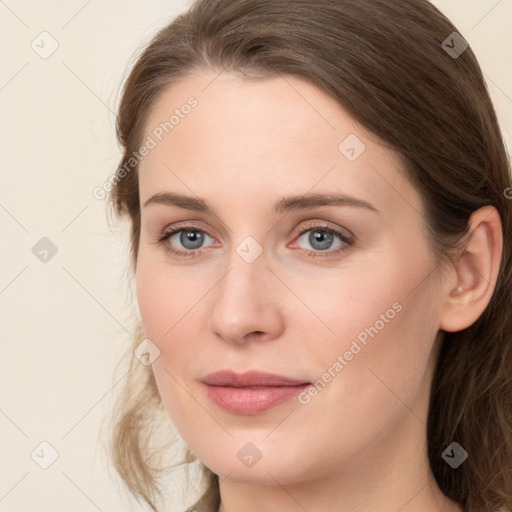 Joyful white young-adult female with long  brown hair and blue eyes