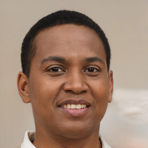 Joyful black young-adult male with short  brown hair and brown eyes